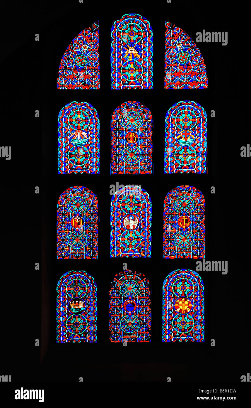 Stained Glass windows at St Maria Geburt Church in North West Germany. It shows the Christian symbols and abstract designs. Stock Photo