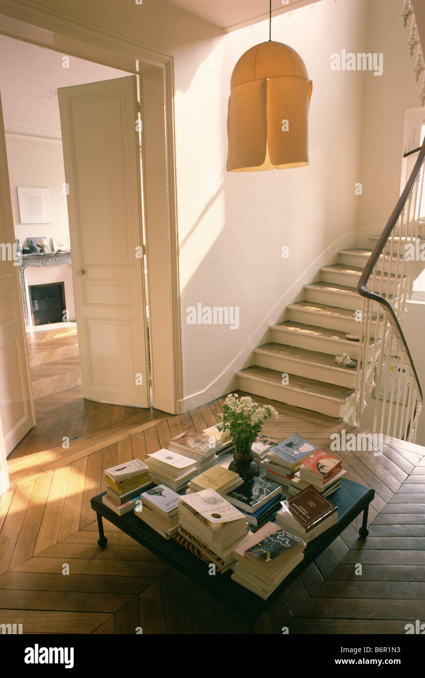 Piles Of Books On Table In Hall With Parquet Flooring And Double