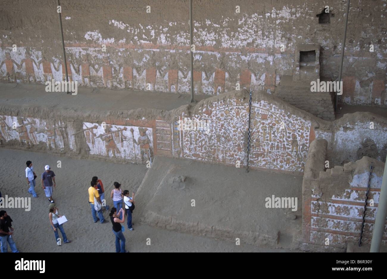 Archaeological students studying friezes on field trip, Huaca de la Luna, near Trujillo, Peru Stock Photo
