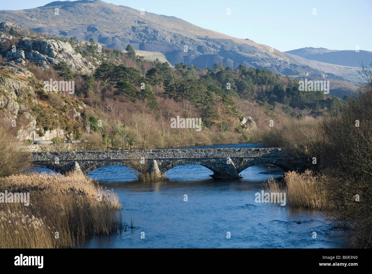 Brynrefail Gwynedd North Wales December old four arch stone bridge over Afon Rhythallt looking towards Snowdonia National Park Stock Photo