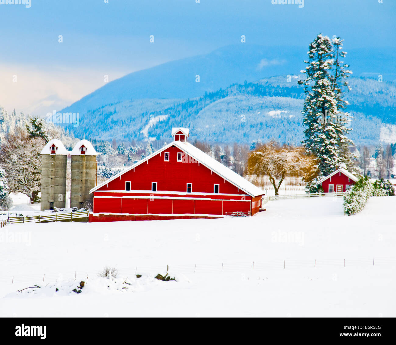 A century old red barn surrounded by a blanket of white after a winter ...