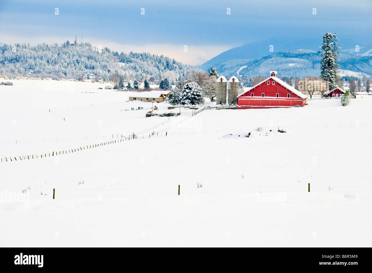 A century old red barn surrounded by a blanket of white after a winter ...