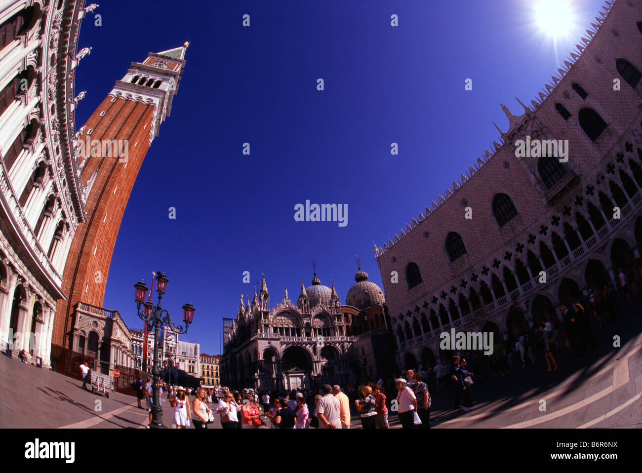 Tourists on St Mark's Square in Venice, Italy, with Campanile bell tower, Basilica di San Marco and Palazzo Ducale Doges Palace. Stock Photo