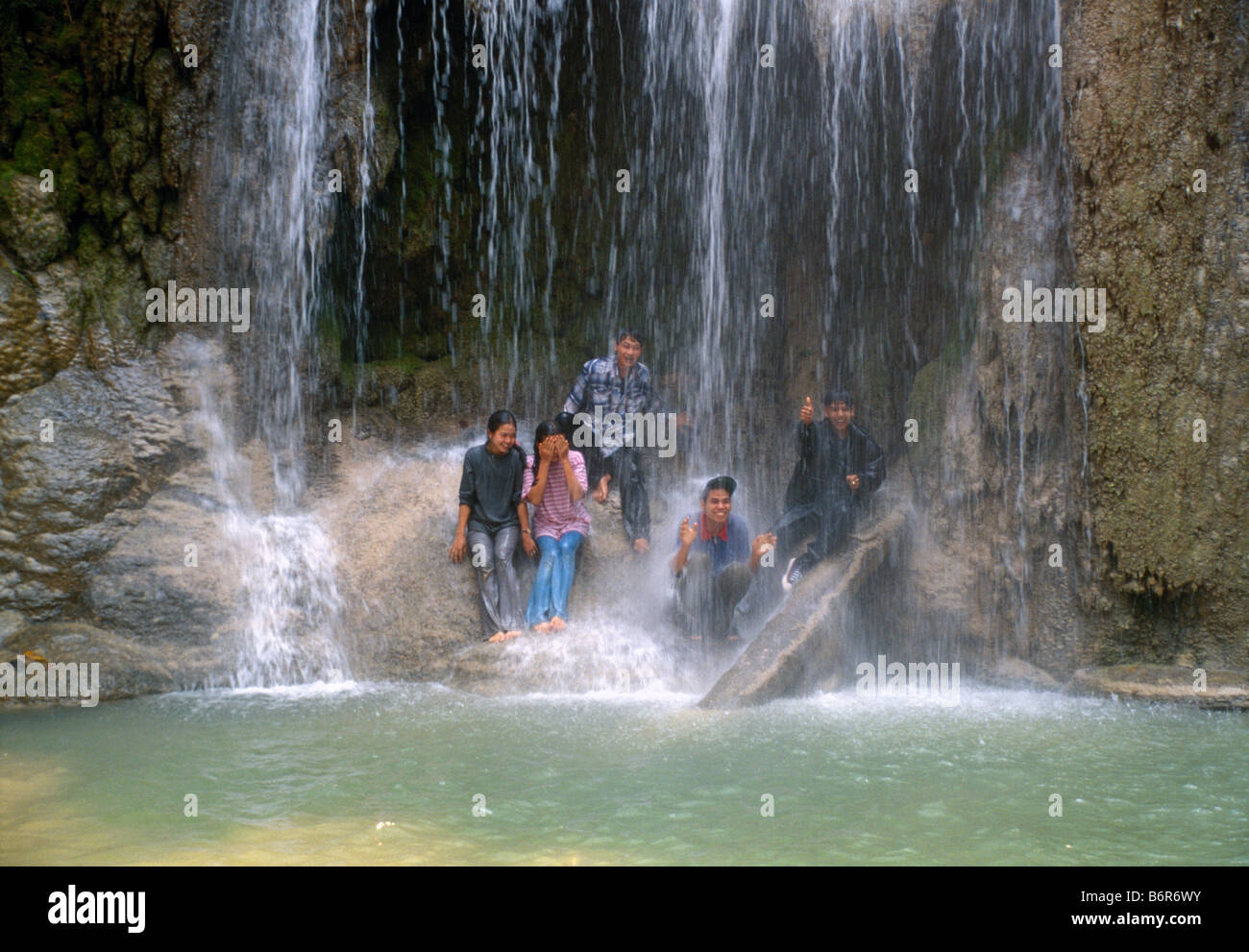 Young laotic people taking a shower under the Tat Kuang Xi waterfall Jugendliche Laoten am Wasserfall Laos Stock Photo