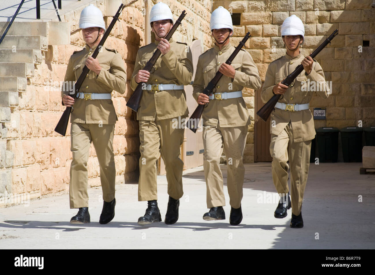 Four soldiers running and holding rifles, Fort Rinella, Kalkara, Malta Stock Photo