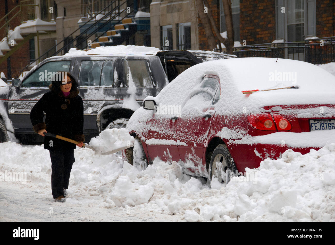 Montrealer digging out her car after a snow storm Stock Photo