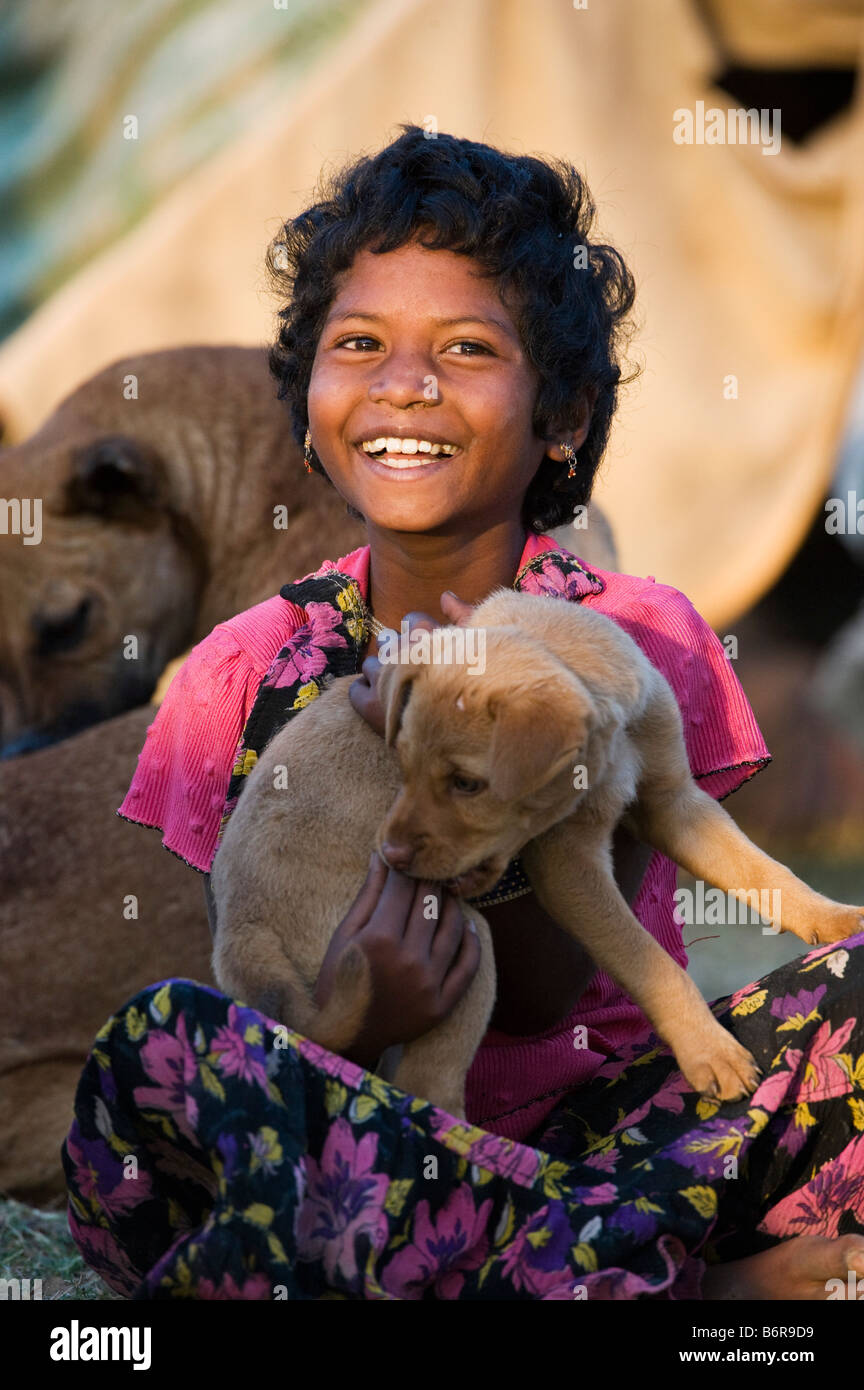 Poor indian girl playing with her puppy dog outside a tent in early morning light Stock Photo - Alamy Poor indian girl playing with her puppy dog outside a tent in early morning light Stock Photo - Alamy