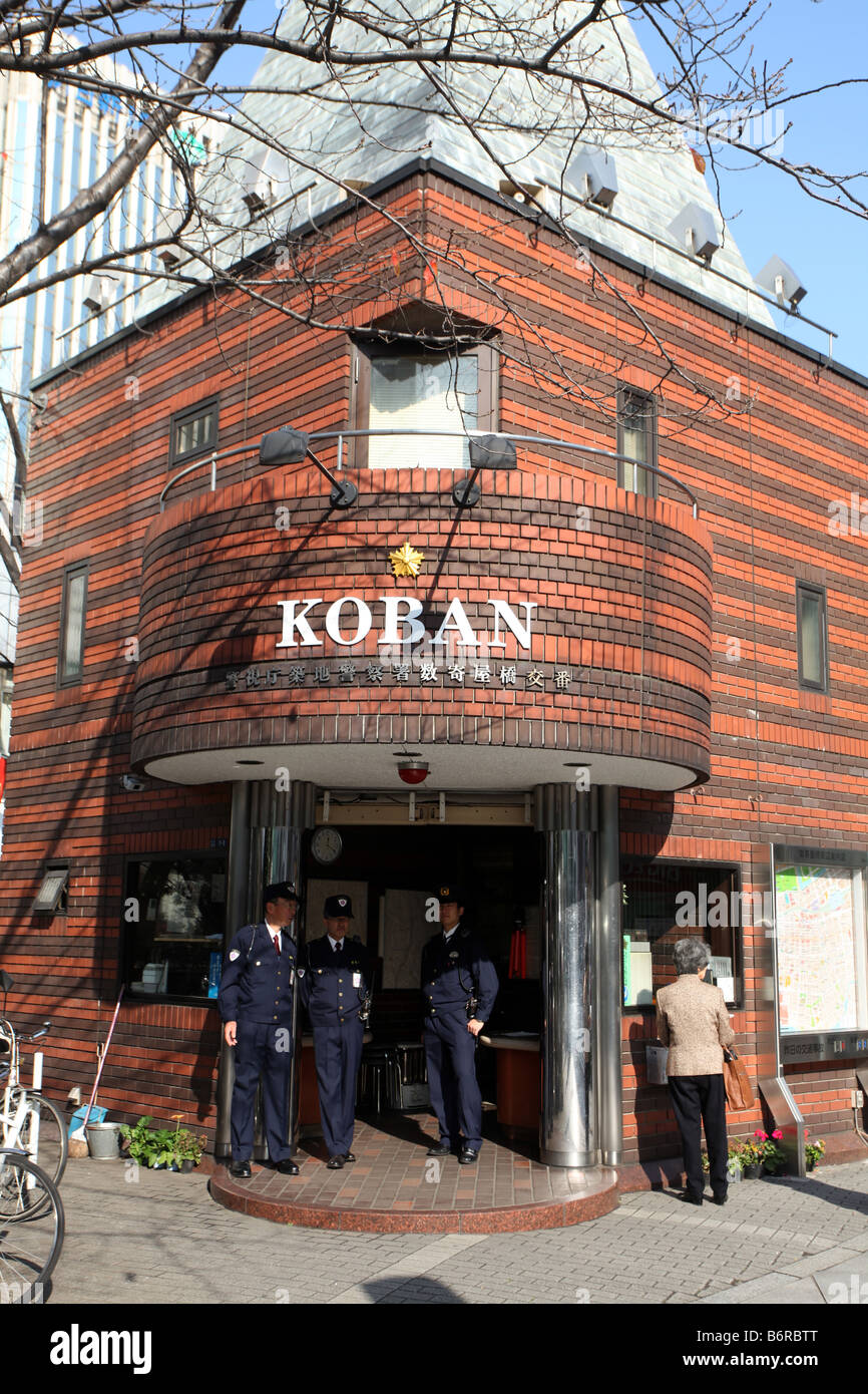 Police Officers standing watch at the Koban in the Ginza District of Tokyo Stock Photo