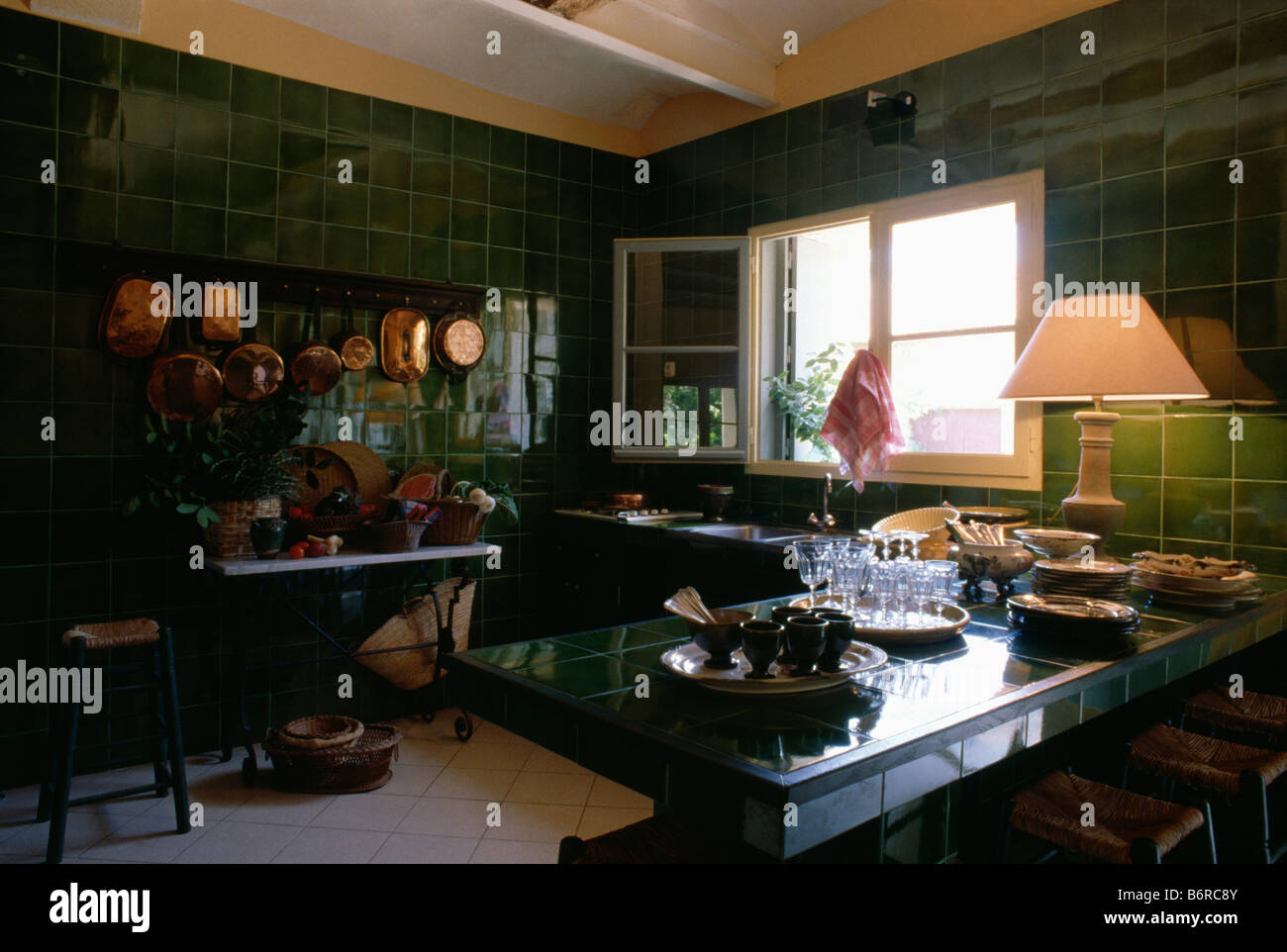 Lighted lamp on worktop in traditional kitchen with green tiled walls Stock Photo Alamy