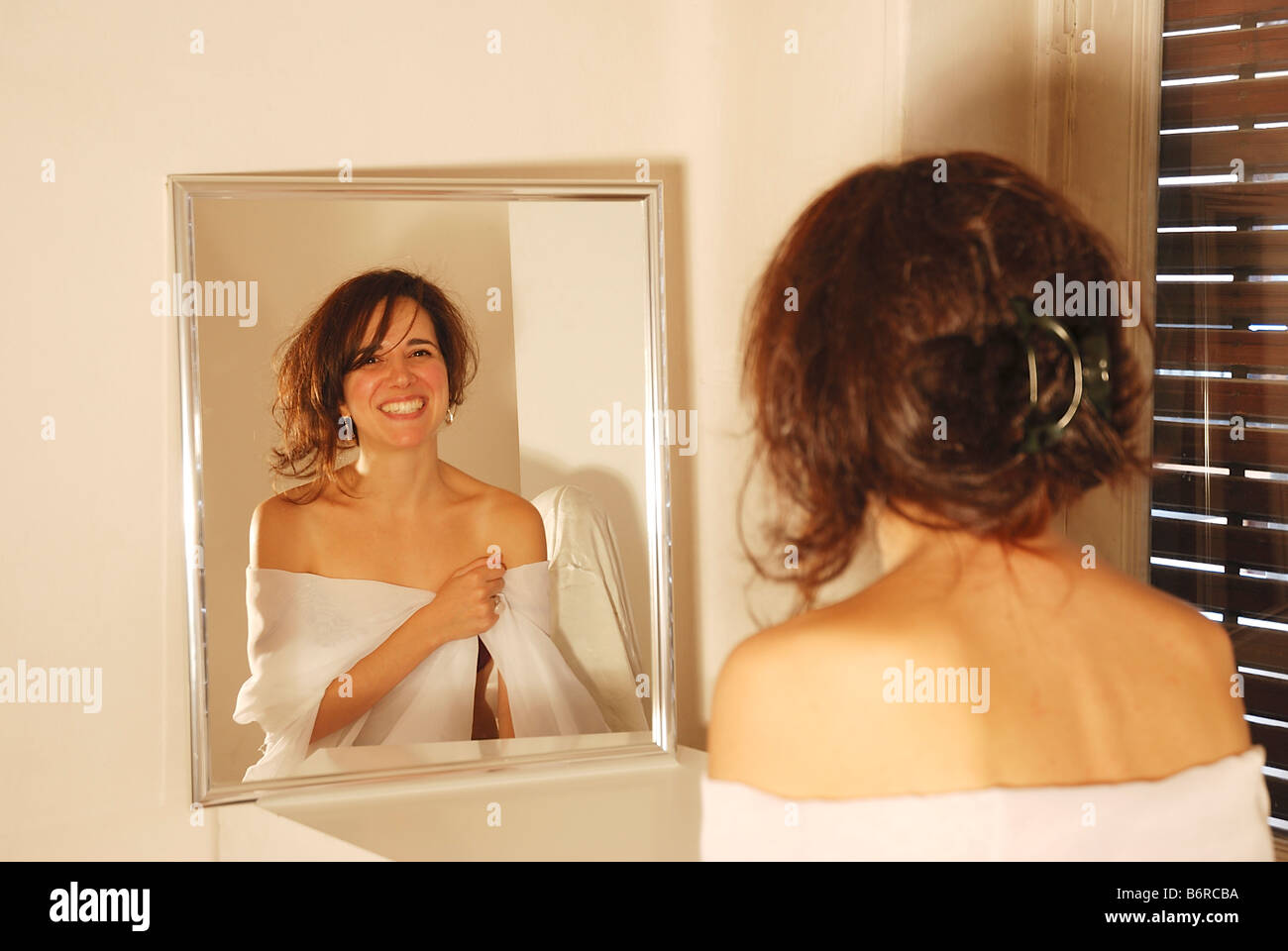 Portrait of young woman smiling reflected on mirror. Stock Photo