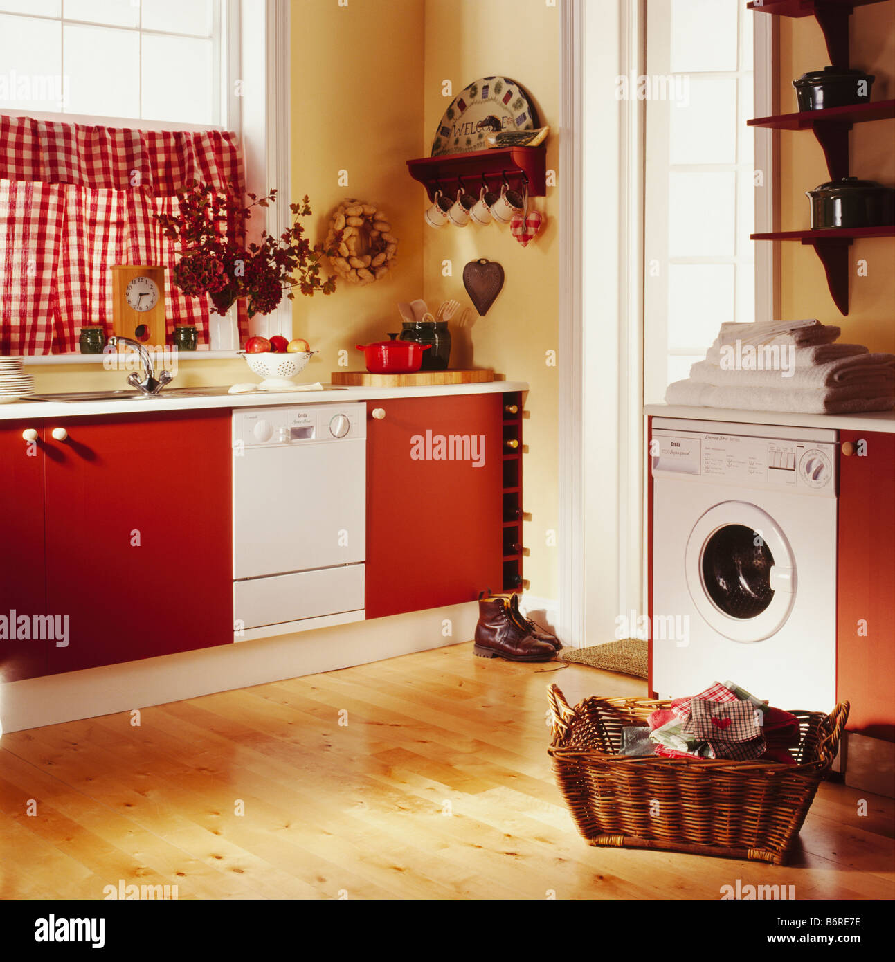 Basket Of Laundry On Wooden Floor In Front Of Washing Machine In