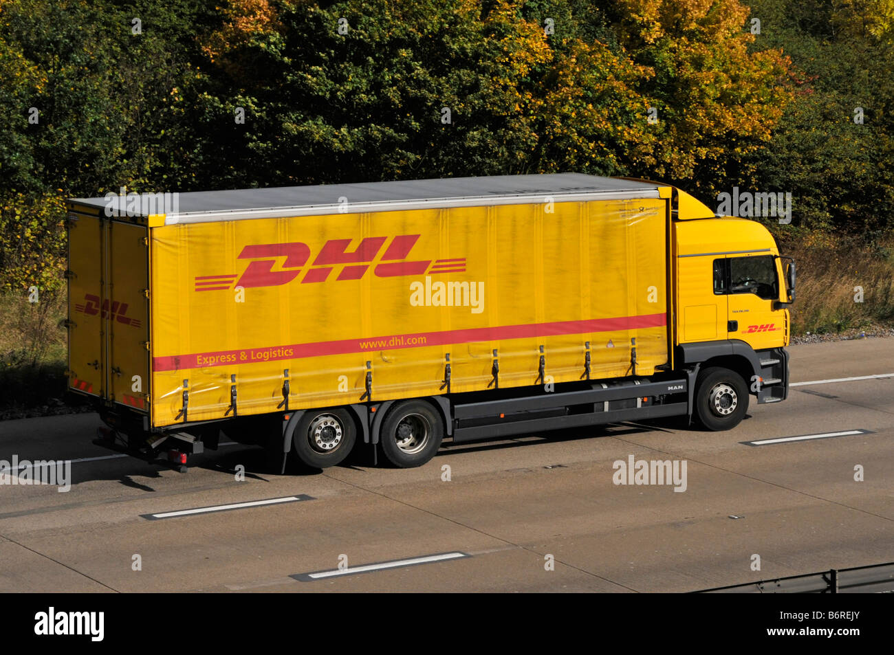 M25 motorway DHL soft sided lorry with raised third axle Stock Photo