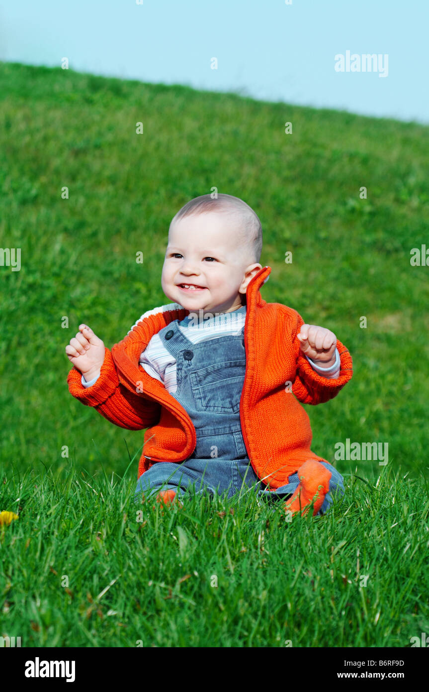 smiling baby sitting on green grass Stock Photo - Alamy