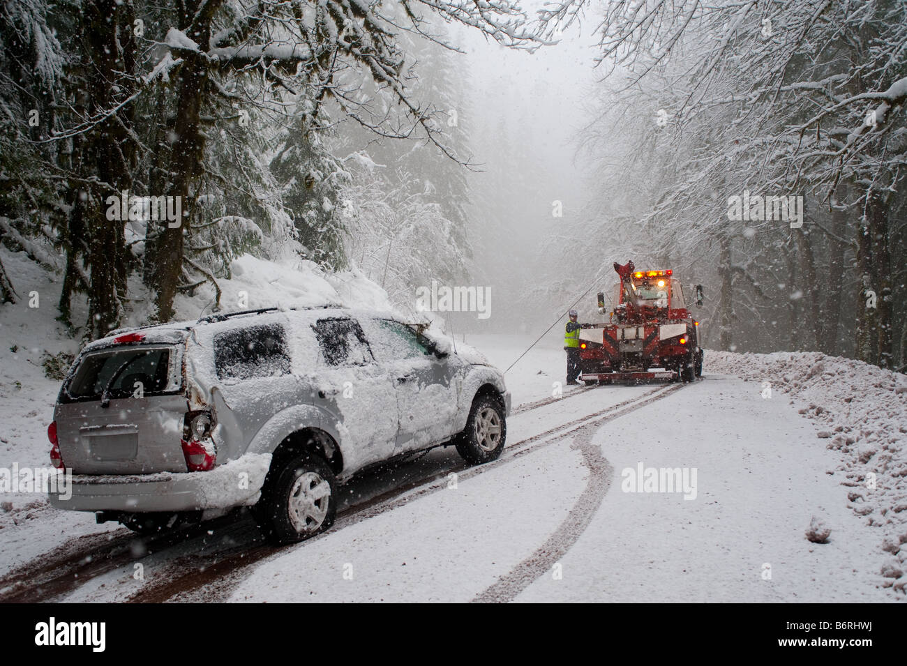 Car being towed after accident in snow storm Stock Photo Alamy