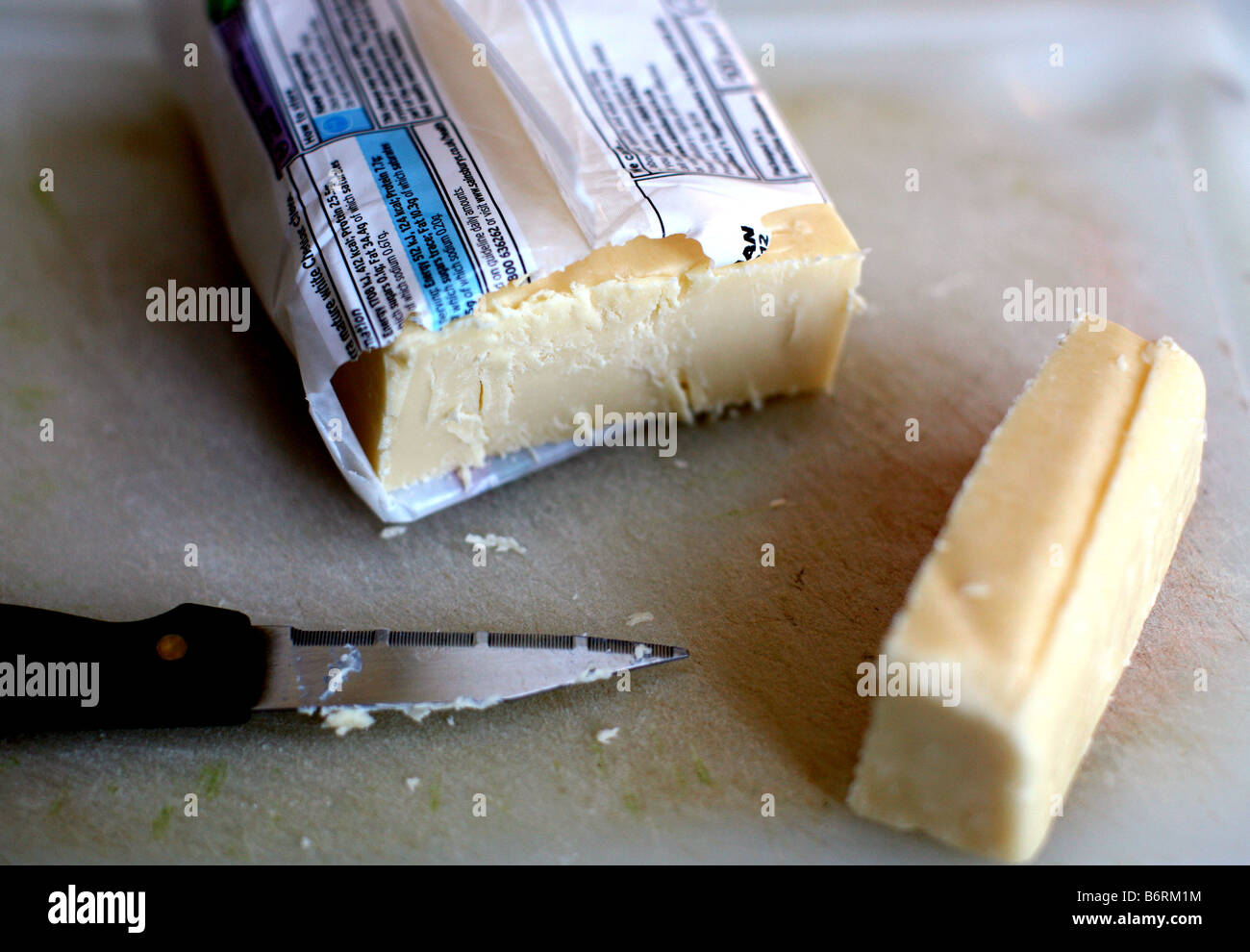 Cut piece of cheddar cheese Stock Photo Alamy