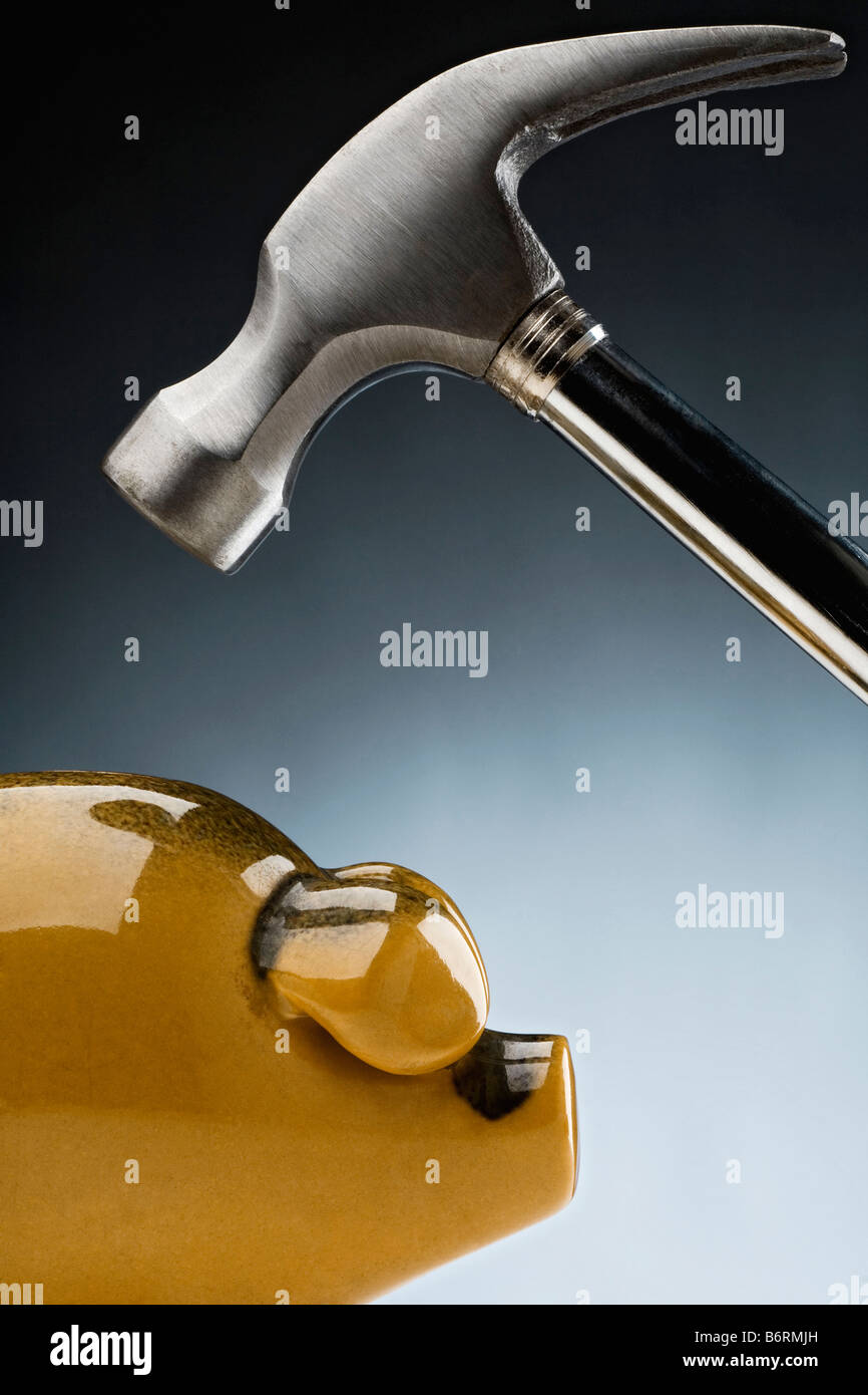 claw hammer coming down on a piggy bank Stock Photo