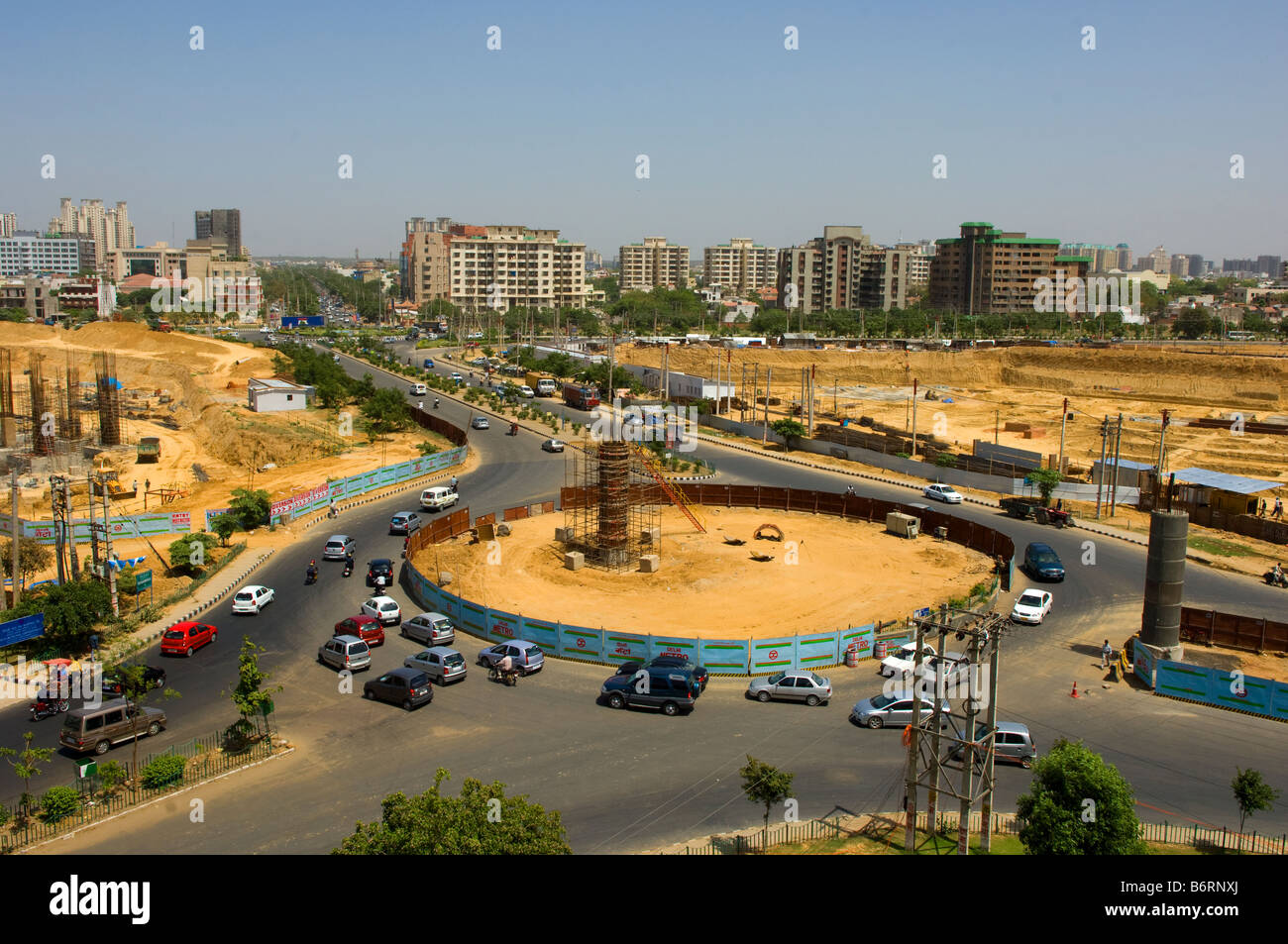 A busy roundabout amongst the construction work extending the Delhi metro that features all over Gurgaon in Haryana, India. Stock Photo