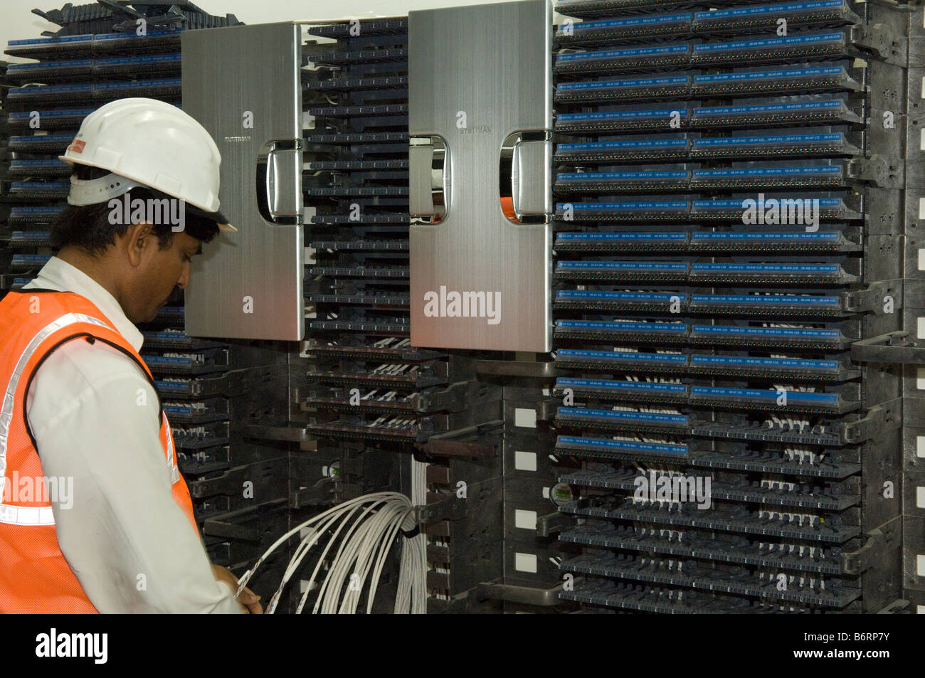 Engineer inspecting a structured cabling installation in a data communications room. Stock Photo