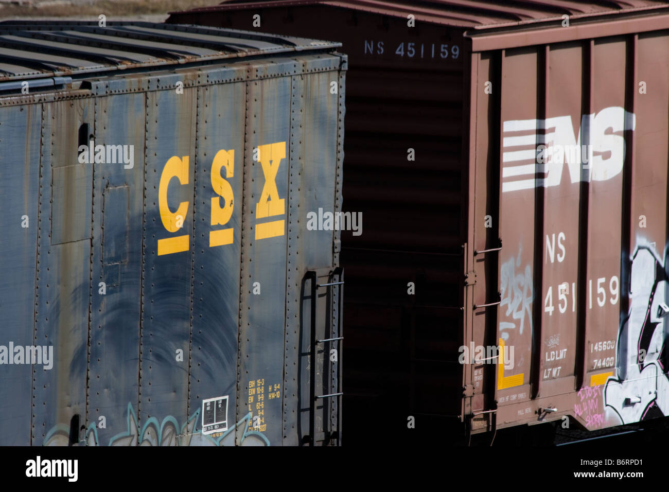 CSX and NS railroad boxcars coupled together in freight train in Rigby