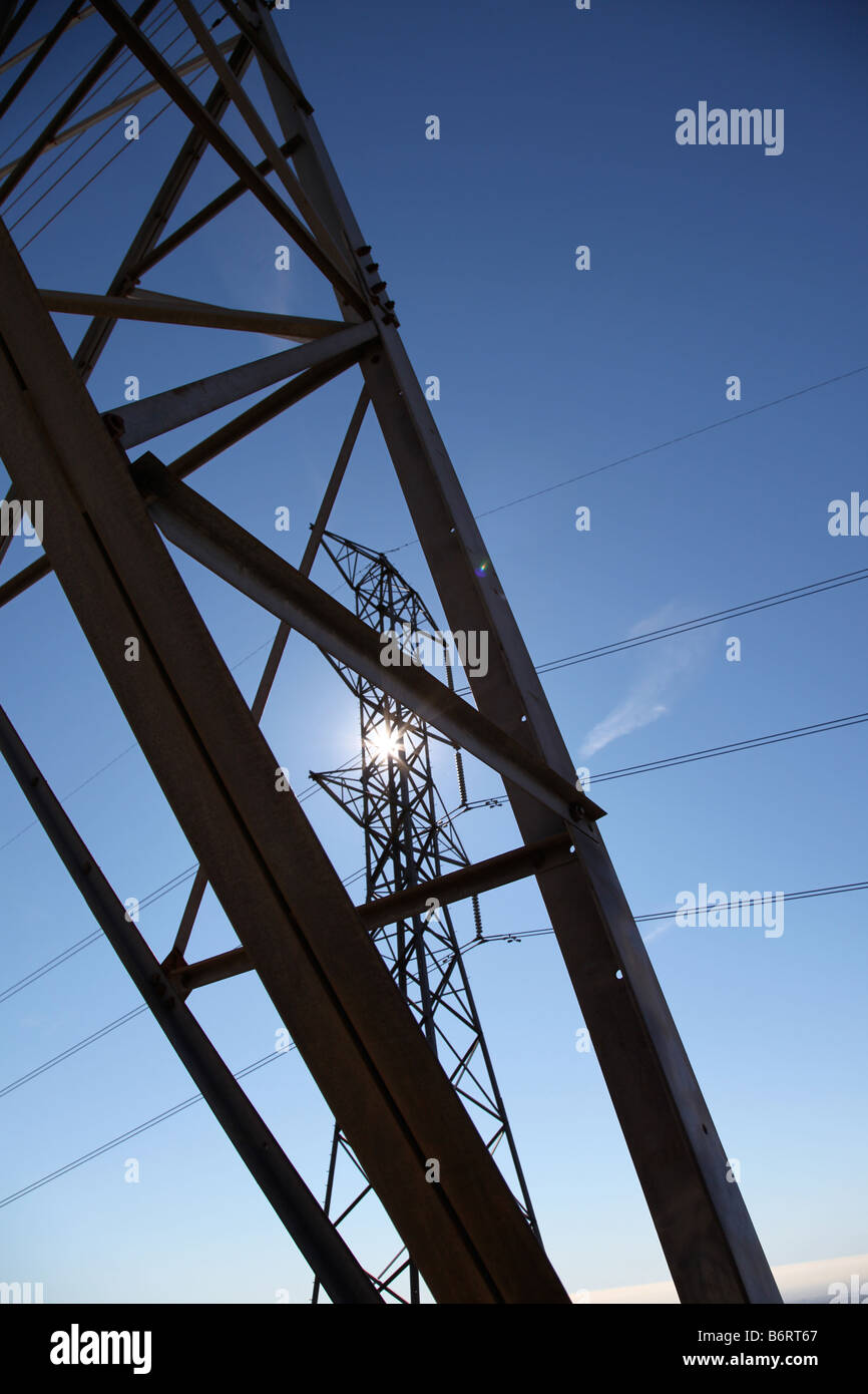 power lines with sun shining and blue sky energy Stock Photo