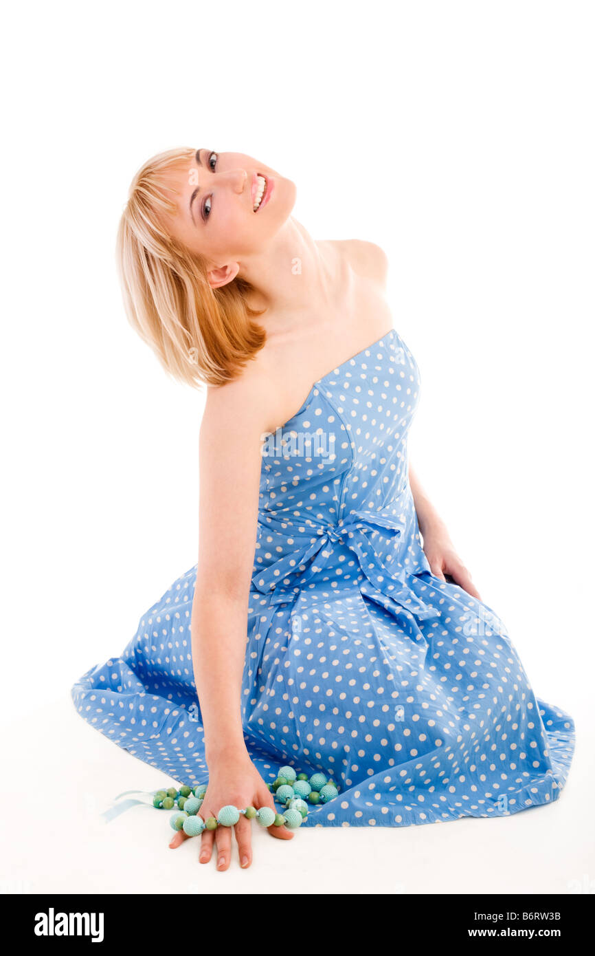 Sitting girl in a blue dress holding beads Stock Photo - Alamy