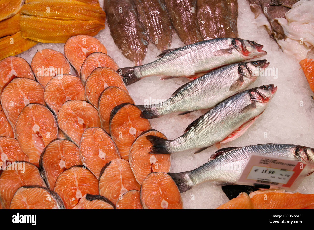 fresh fish on ice in a supermarket; whole trout and fillets of salmon Stock Photo