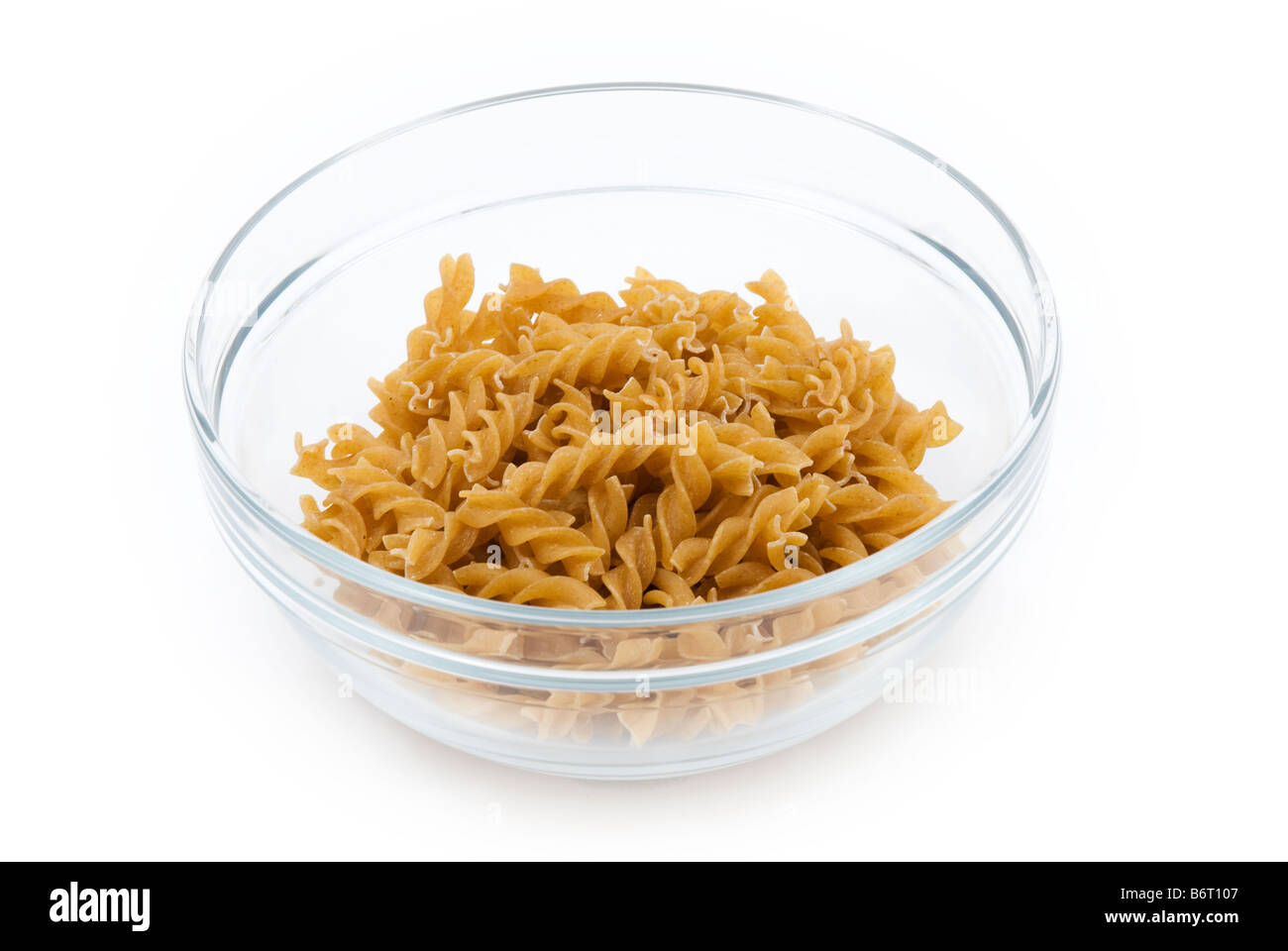 glass bowl with dried organic wholemeal fusilli pasta Stock Photo