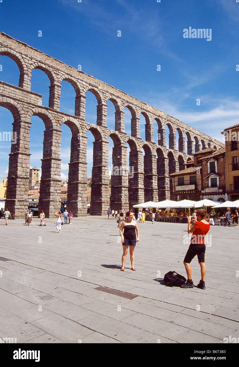 Tourists taking photos by the Roman Aqueduct. Segovia. Castile Leon. Spain. Stock Photo
