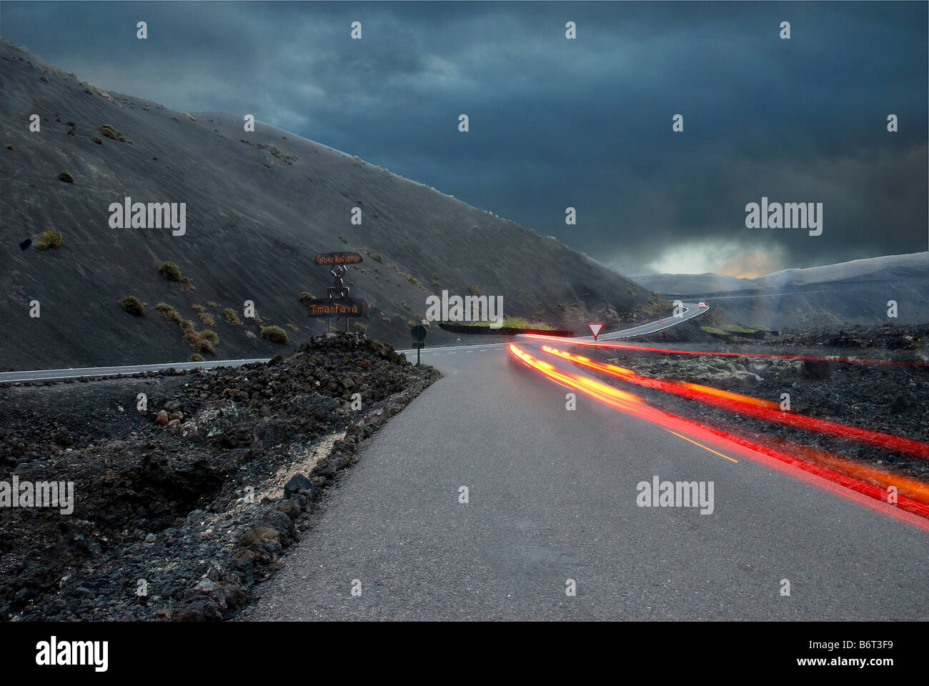 Road and light trail. Timanfaya National Park. Lanzarote Island. Canary Islands. Spain. Stock Photo