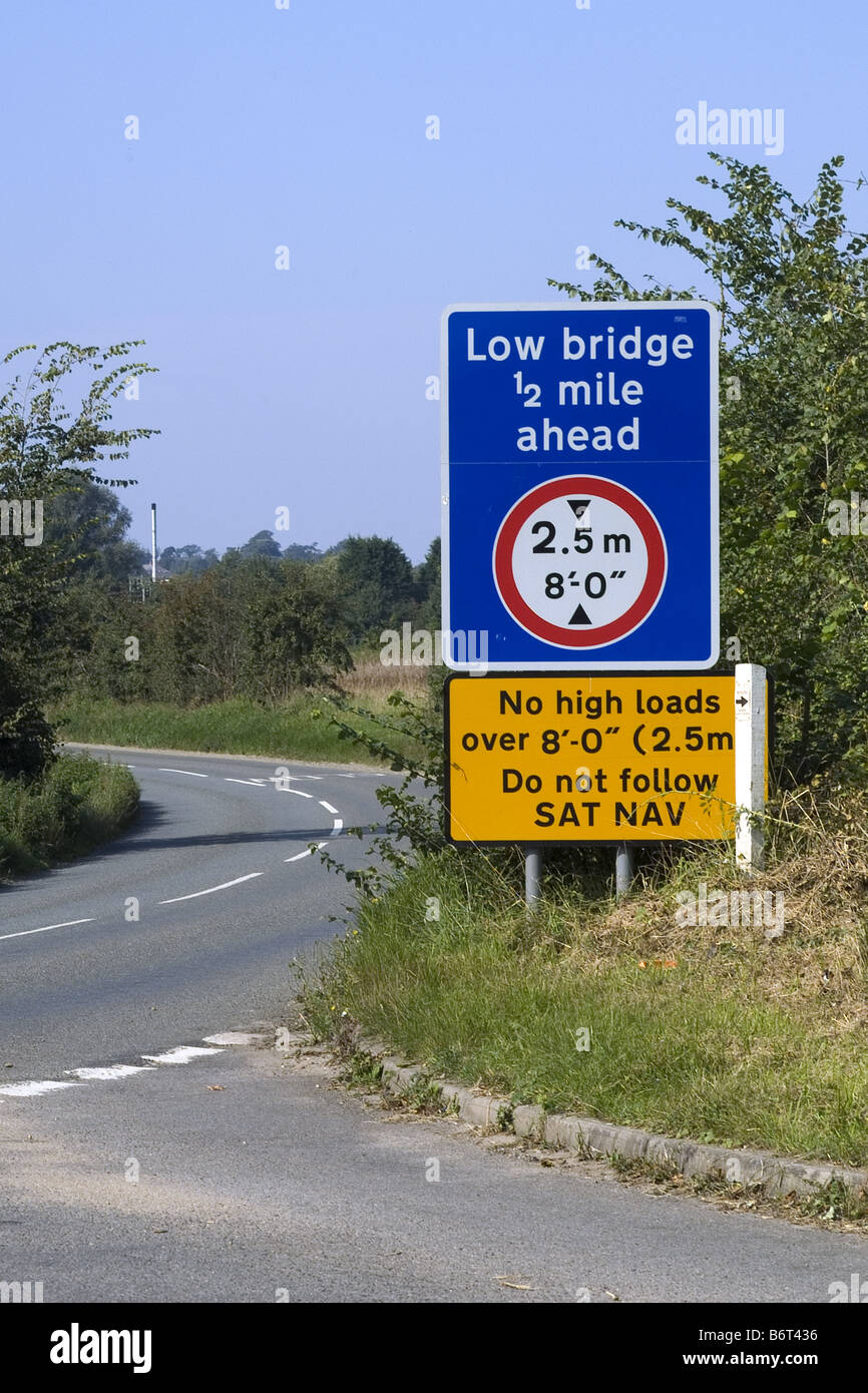 Road sign warning of a low bridge ahead and instructing not to follow sat nav Stock Photo