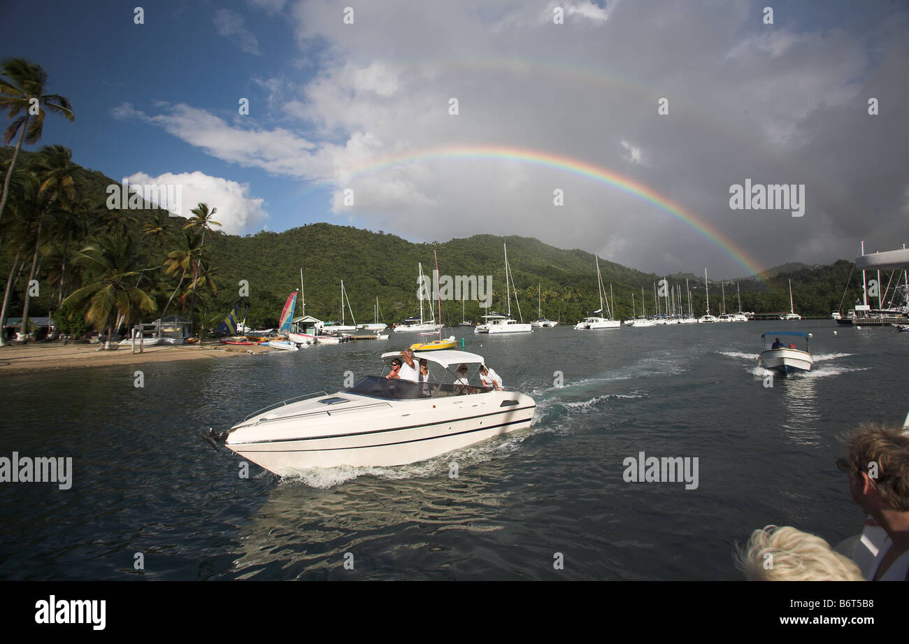 A rainbow appears over a sailing boar moored in Marigot Bay, St Lucia, Windward Islands, Caribbean in the West Indies. Stock Photo