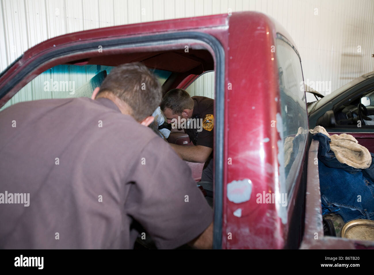 Deputy sheriffs searching vehicle for narcotics. Vehicle was abandoned by owner. Stock Photo