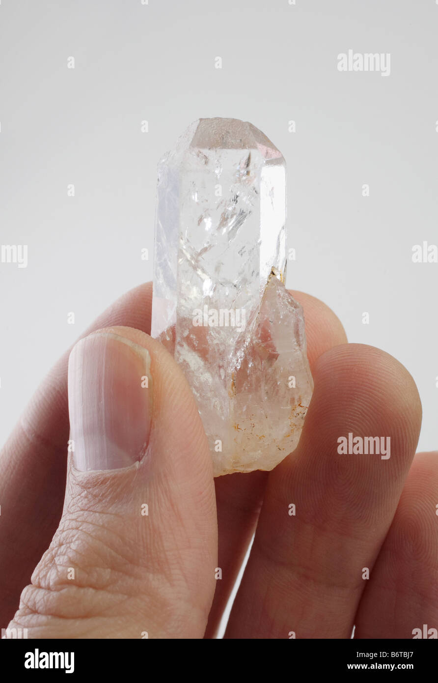 Hands holding clear quartz crystal