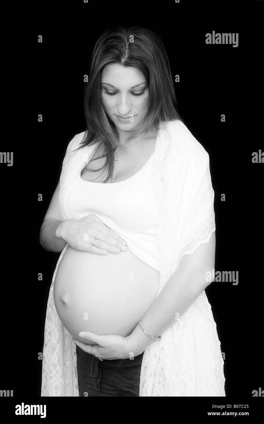 Beautiful Pregnant woman holding her belly Black background Stock Photo ...