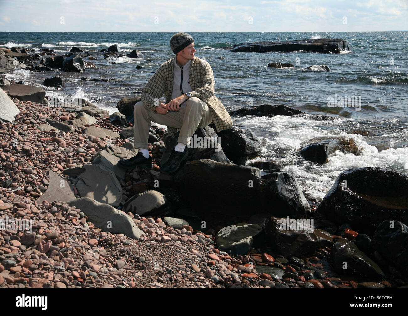 Man sitting on rock shore hi-res stock photography and images - Alamy