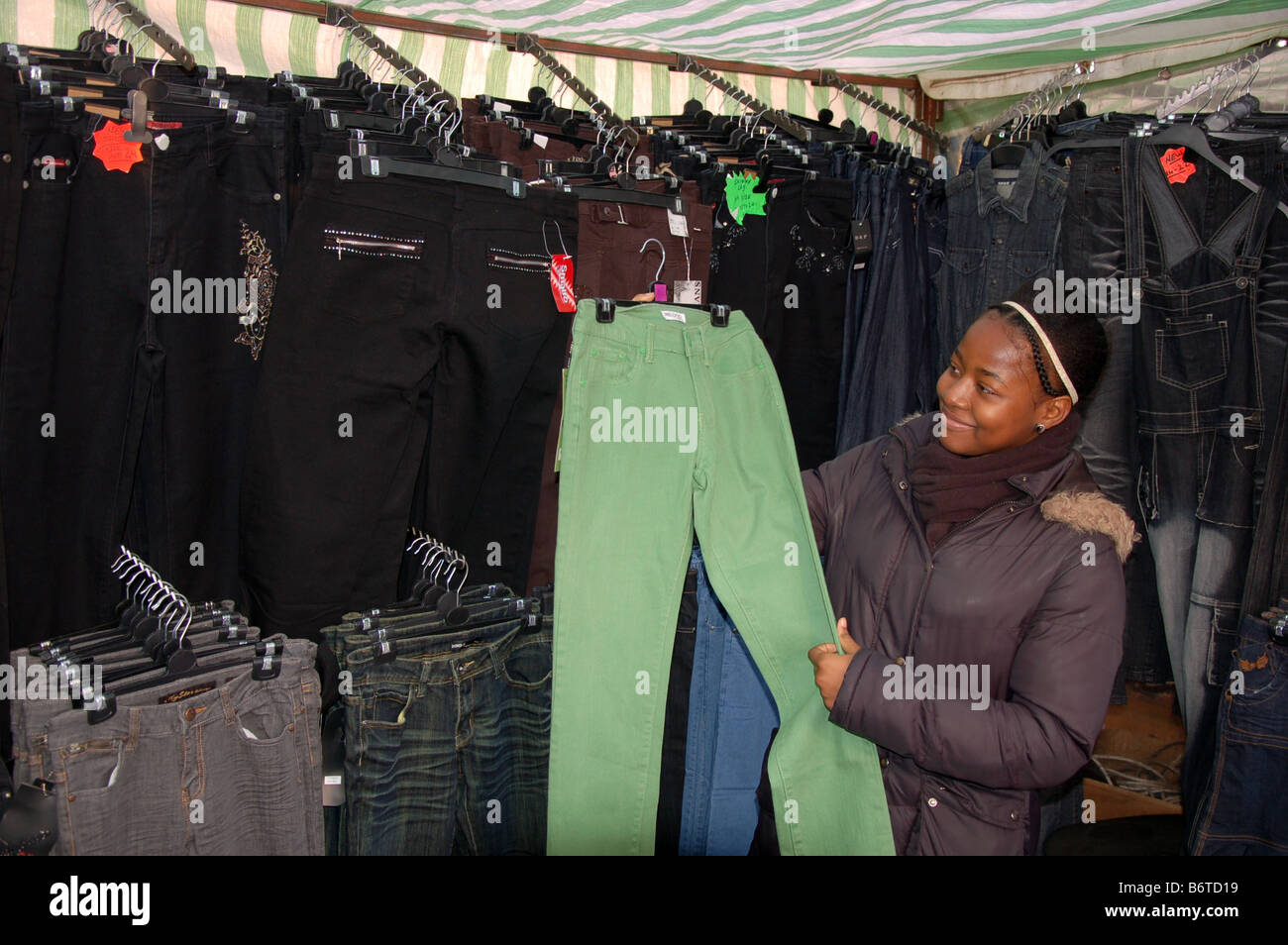 A young girl shop for jeans in Dalston Market London, England, Uk Stock