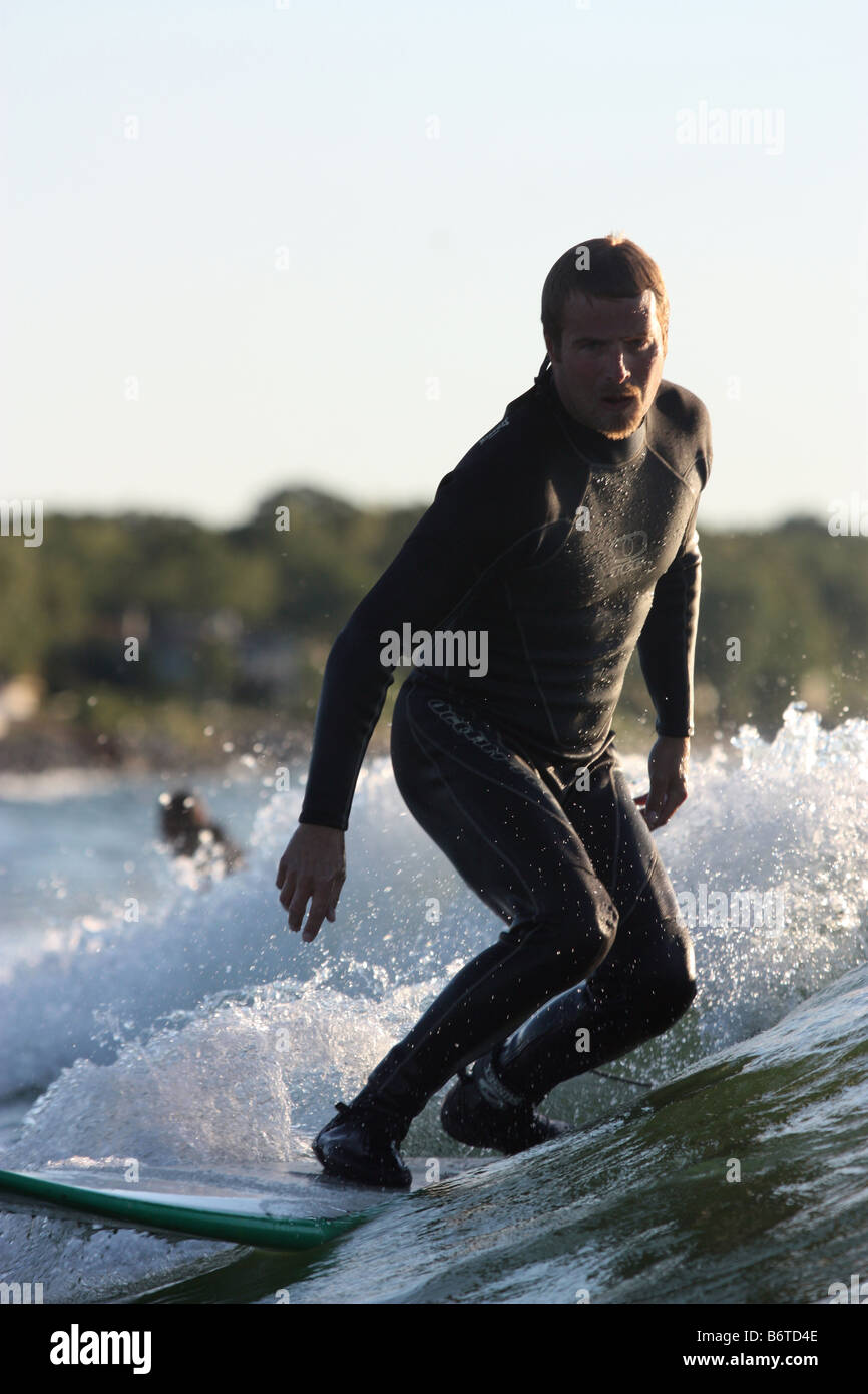 Surfer in wetsuit riding a wave in the fresh inland waters of Lake