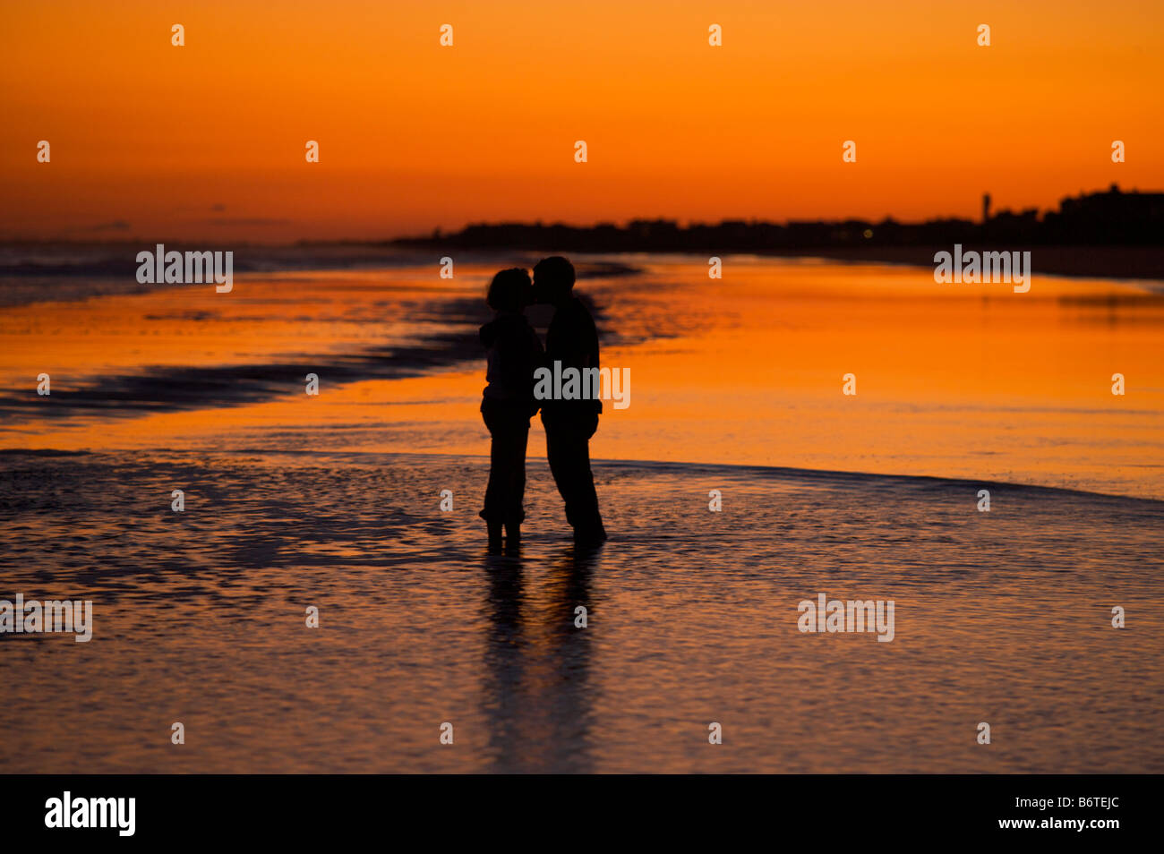 A couple embrace during sunset on the beach on Isle of Palms South Carolina Stock Photo