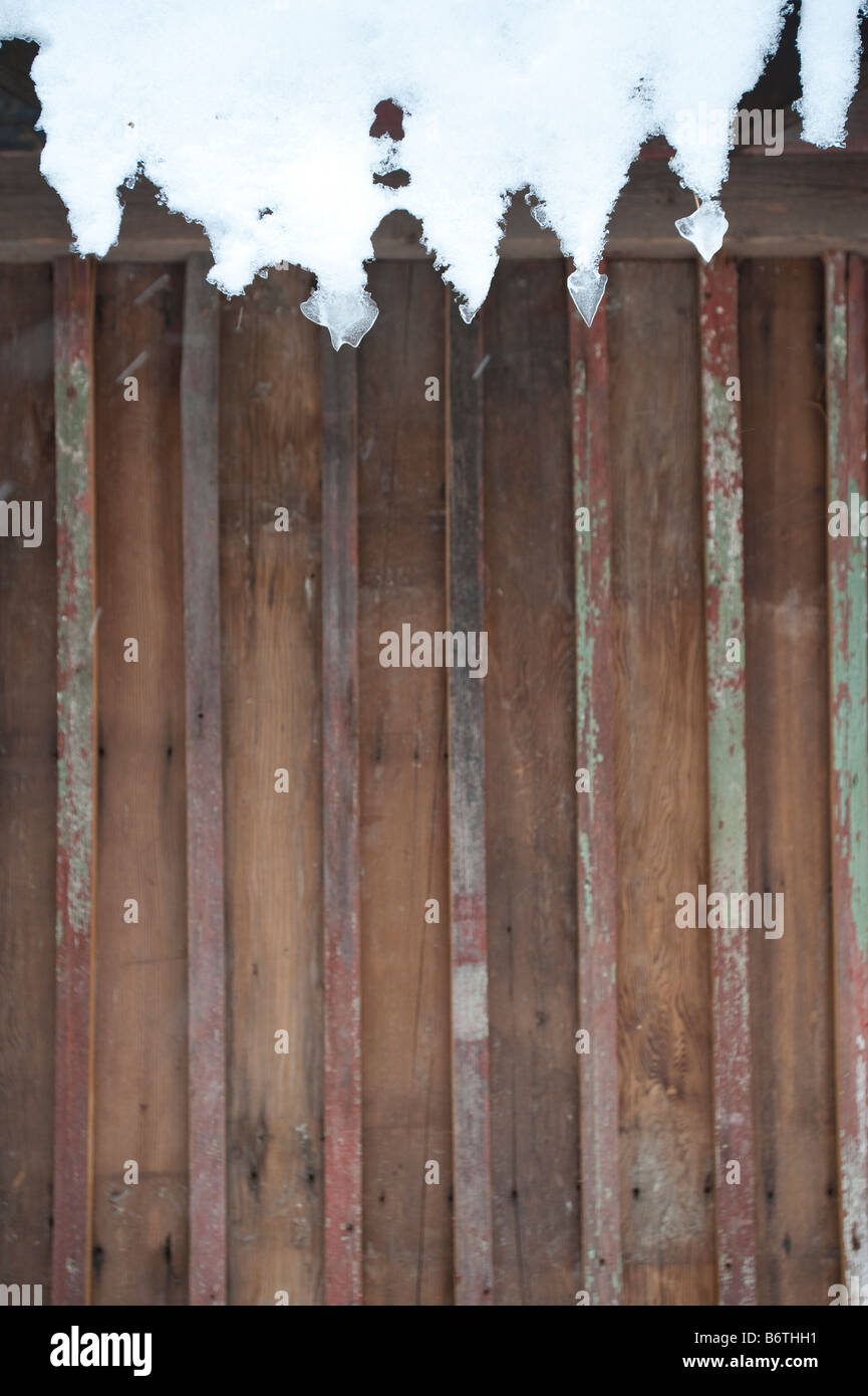 ICICLES HANG OFF ROOF OF OLD BARN Stock Photo