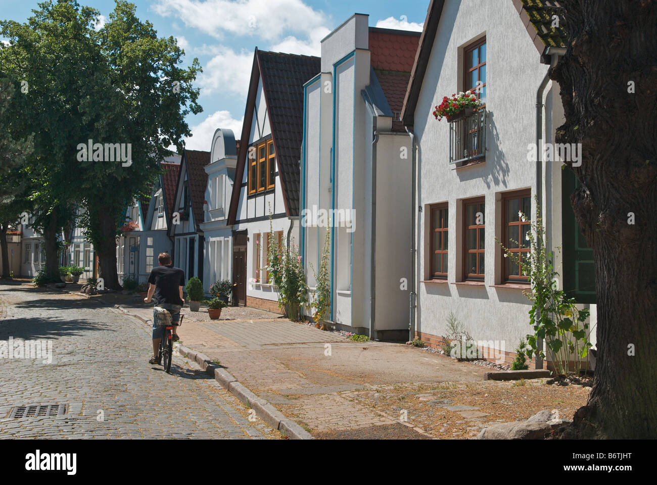 Pretty row of houses and Bed and Breakfast guesthouses in quiet cobble stoned street Alexandrinenstrasse Warnemunde Germany Stock Photo