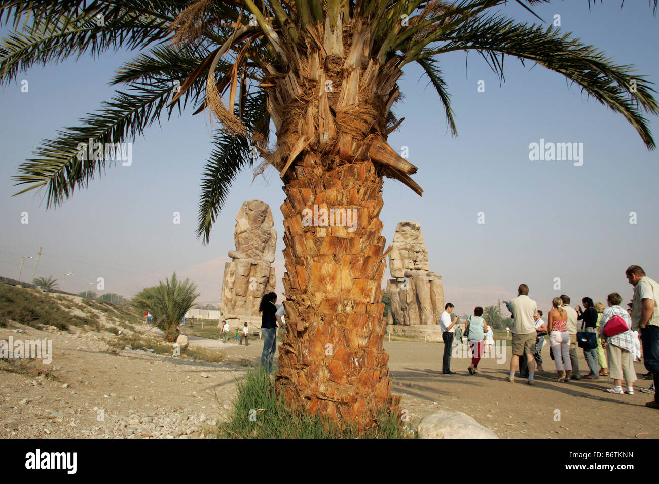 The Colossi of Memnon are two massive stone statues of Pharaoh Amenhotep III on the West Bank of the River Nile. Stock Photo