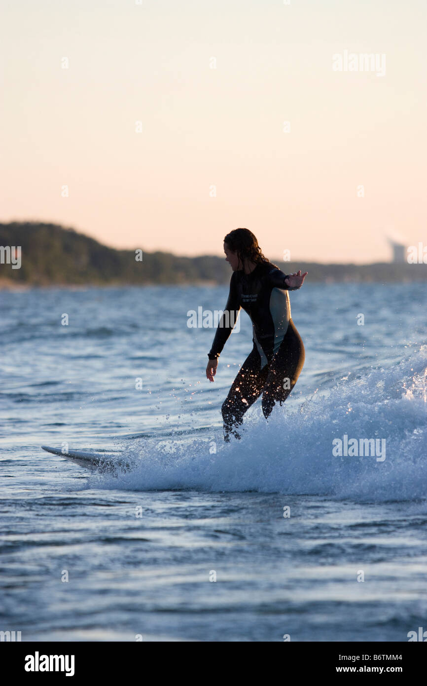 Cute girl balancing her board on a freshwater wave in Lake Michigan Stock Photo
