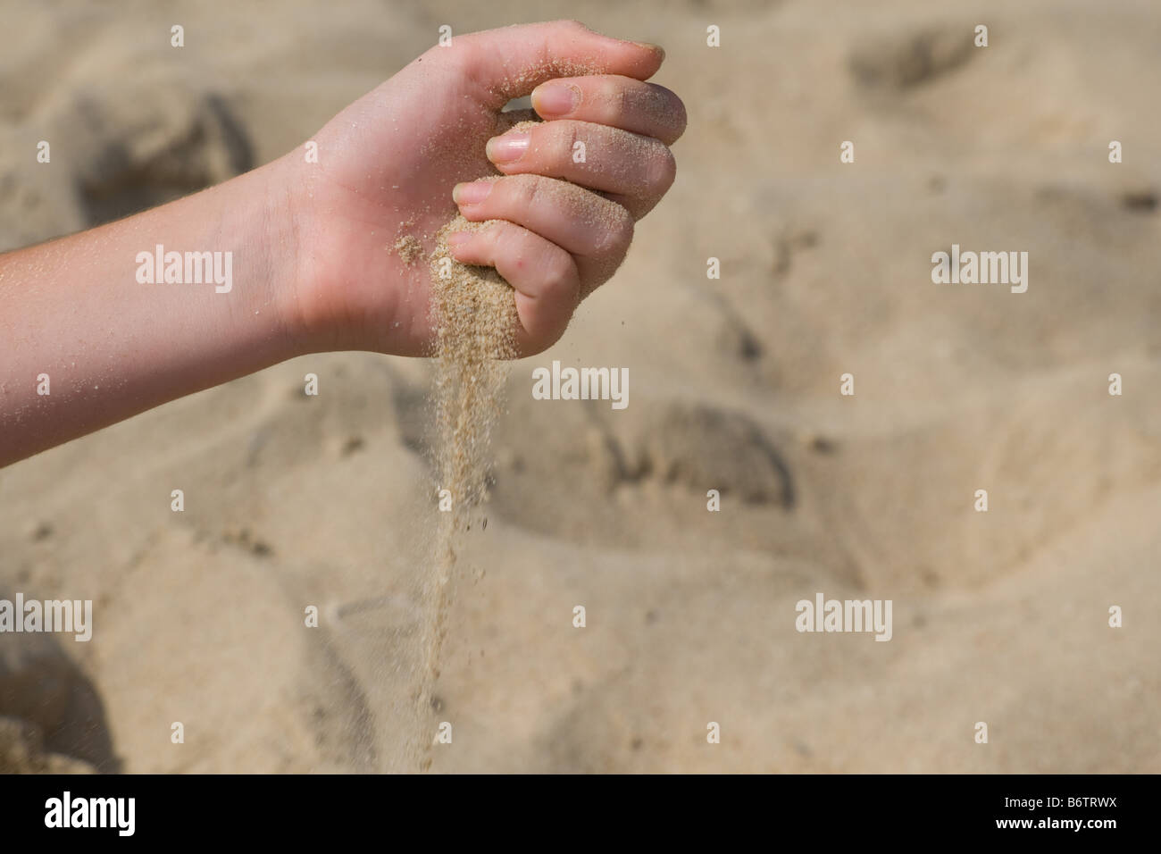 Grains of sand slipping through a childs hands at beach Stock Photo Alamy