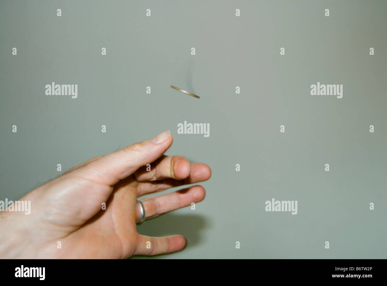 A coin flipped caught in mid air Stock Photo