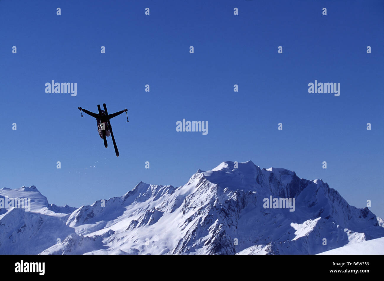 Skier jumping into the air with mountain backdrop Wonderland New Zealand Stock Photo