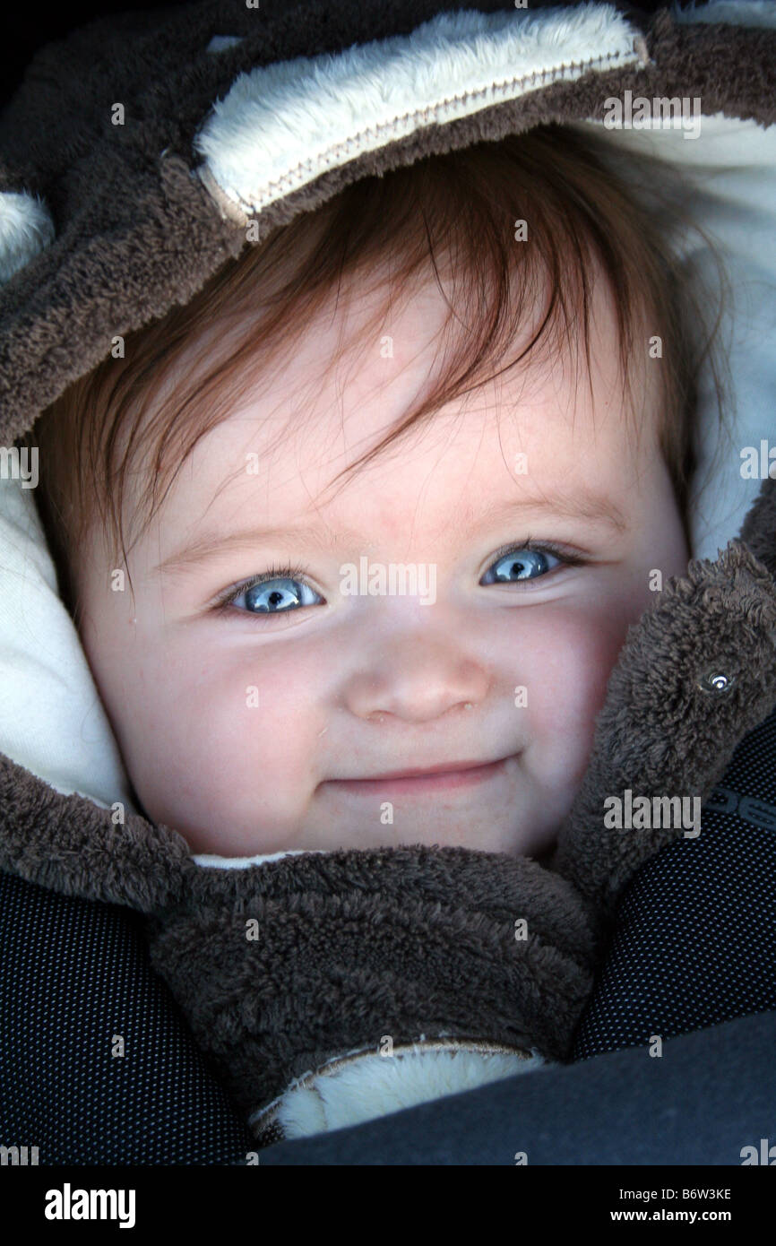 Beautiful Blue Eyed Brown Haired Baby Smiling in Pram Stock Photo
