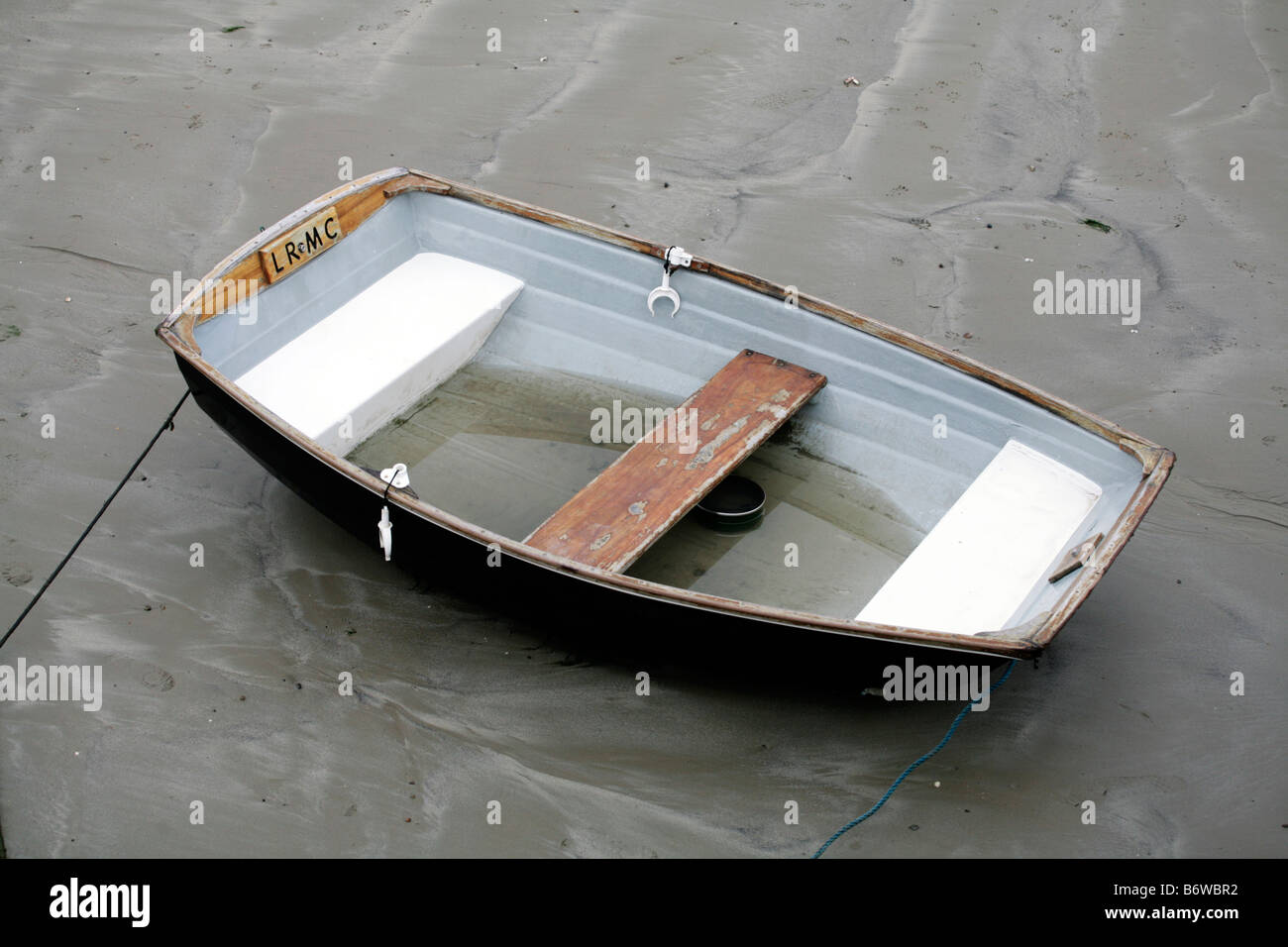 A single rowing boat in Lyme Regis harbour, Dorset UK. Stock Photo