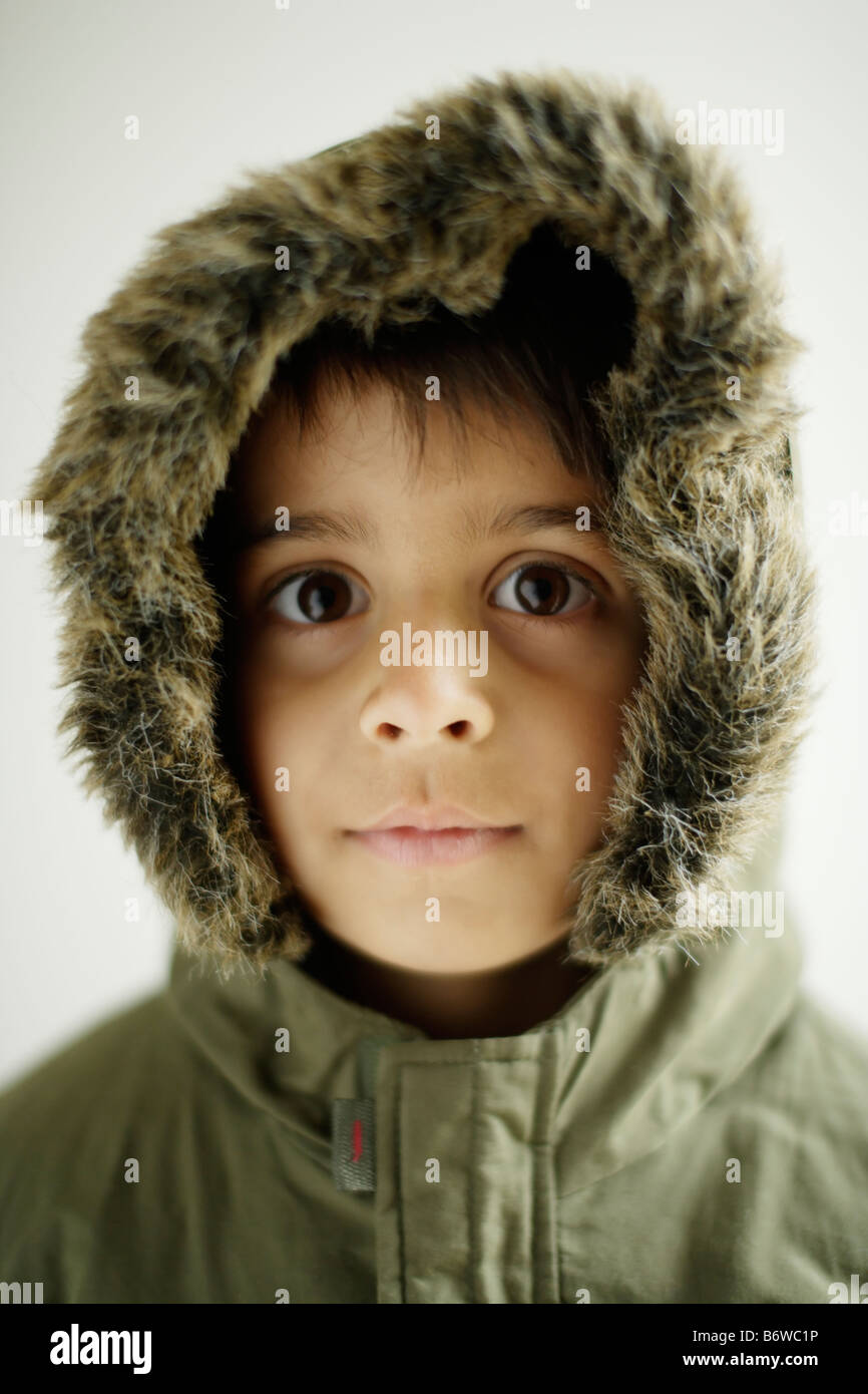 Child wears Parka coat with hood zipped up Boy aged six years Stock Photo