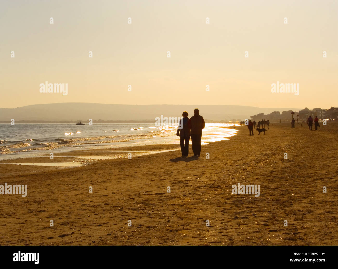 A couple walking on Bournemouth beach at sunset. Dorset. UK. Stock Photo