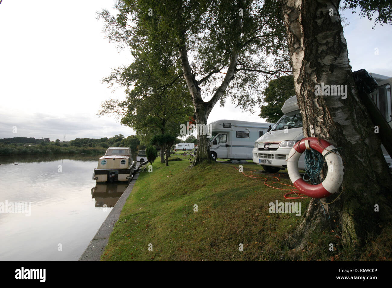 Motorhomes camped by the River Weaver near Northwich Cheshire with scooters attached at the back enjoying the serenity Stock Photo